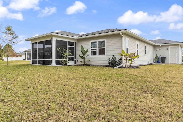 rear view of property featuring a sunroom and a lawn