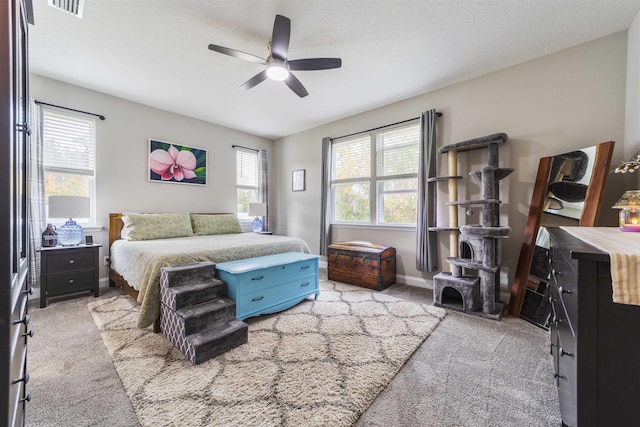 carpeted bedroom with ceiling fan and a textured ceiling