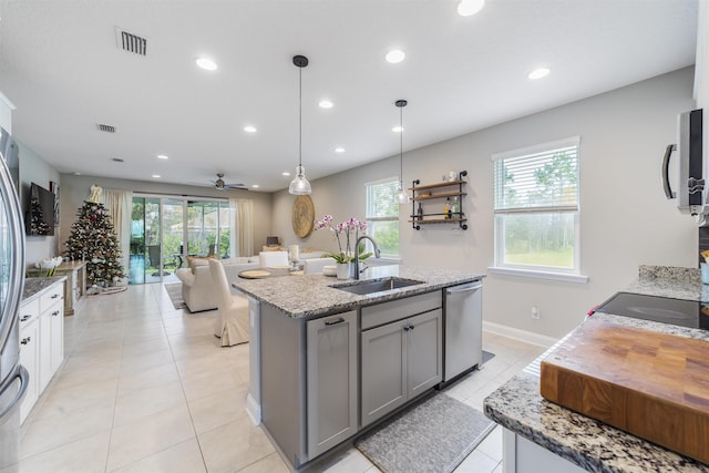 kitchen featuring gray cabinetry, ceiling fan, sink, stainless steel dishwasher, and pendant lighting