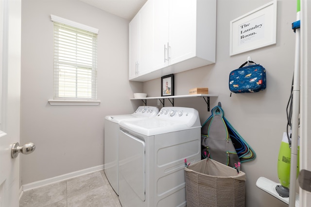 laundry room with washer and clothes dryer, light tile patterned flooring, and cabinets