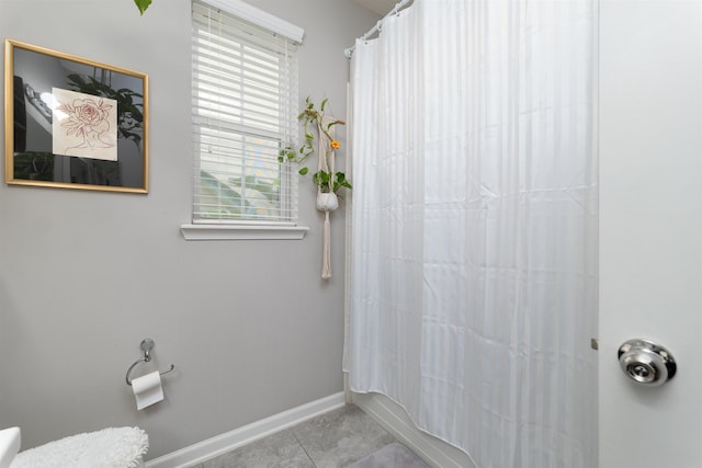 bathroom with tile patterned flooring and shower / bath combo