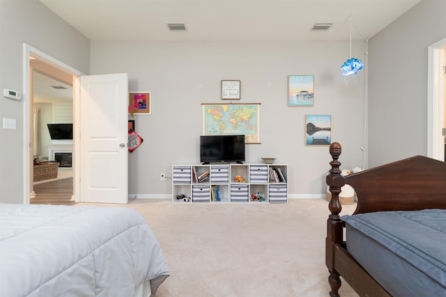 bedroom with a fireplace and carpet floors