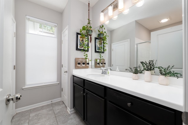 bathroom with tile patterned flooring, vanity, and walk in shower