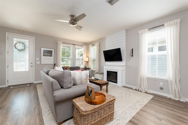 living room with ceiling fan and light hardwood / wood-style flooring