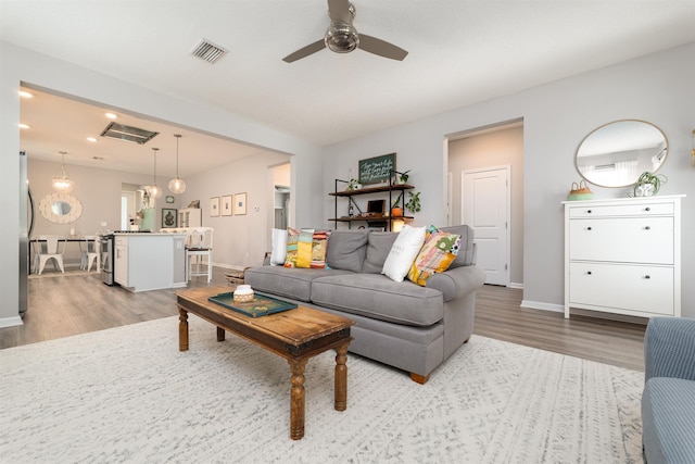 living room featuring ceiling fan and light wood-type flooring