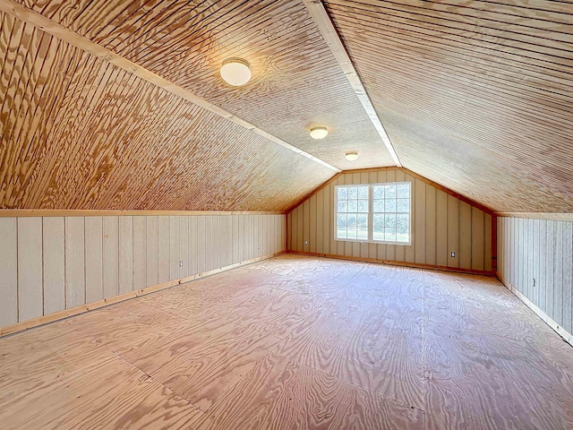 additional living space featuring wood walls, lofted ceiling, and wooden ceiling