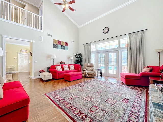 living room with french doors, ceiling fan, crown molding, wood-type flooring, and high vaulted ceiling