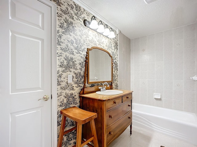 bathroom with tile patterned floors, a washtub, vanity, and a textured ceiling