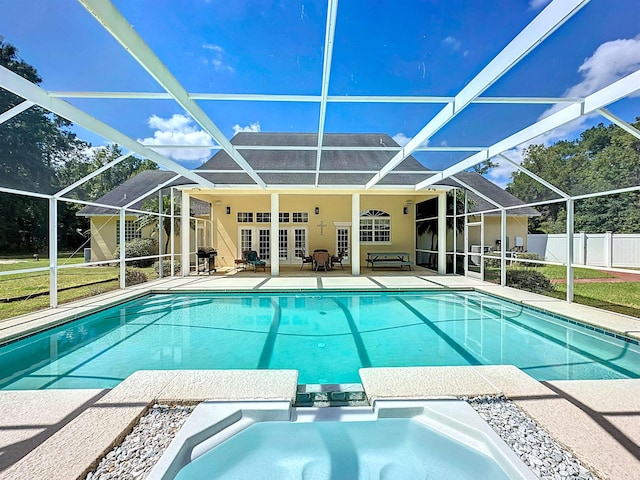 view of swimming pool with an in ground hot tub, french doors, area for grilling, and a lanai