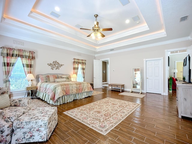 bedroom featuring ceiling fan, a raised ceiling, ornamental molding, and dark wood-type flooring