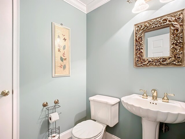 bathroom with crown molding, sink, and toilet