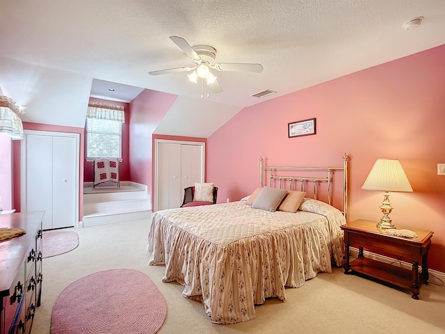 carpeted bedroom featuring ceiling fan, lofted ceiling, and a textured ceiling