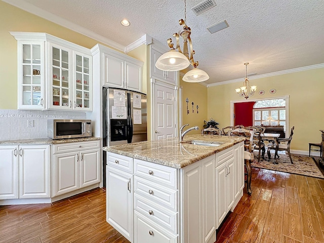 kitchen with hardwood / wood-style flooring, sink, decorative light fixtures, and appliances with stainless steel finishes