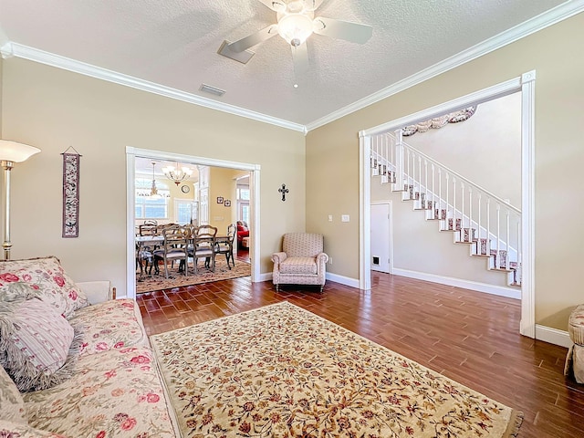 living room with ceiling fan with notable chandelier, a textured ceiling, dark hardwood / wood-style floors, and ornamental molding