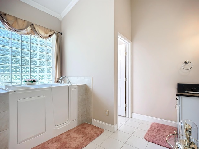 washroom with light tile patterned floors, washer / clothes dryer, and ornamental molding