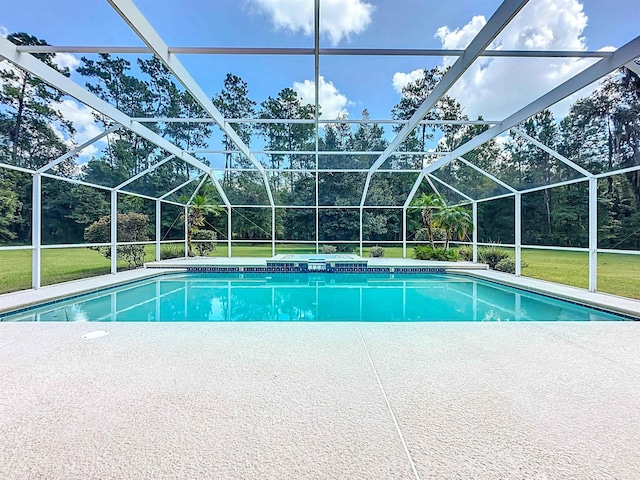 view of swimming pool featuring glass enclosure, a patio area, and a yard