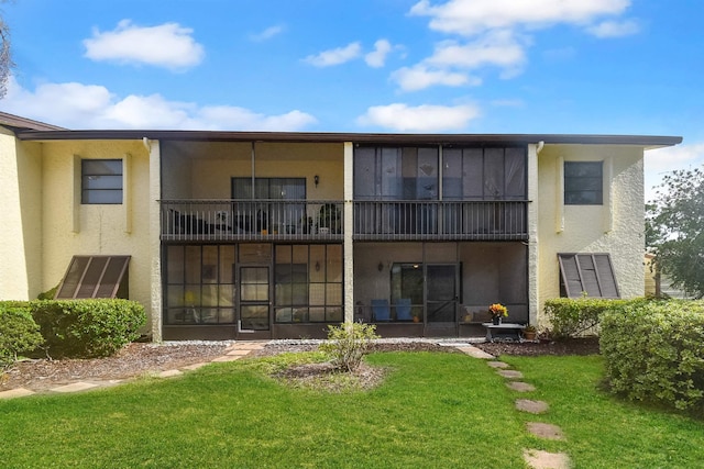 back of property featuring a yard and a balcony