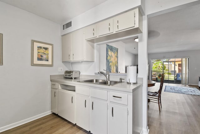 kitchen with white cabinetry, sink, and hardwood / wood-style floors