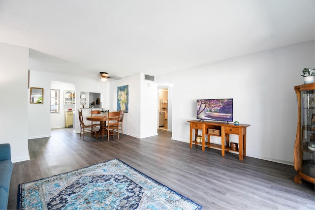 living room featuring ceiling fan and dark hardwood / wood-style flooring