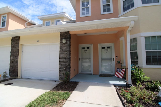 entrance to property with concrete driveway and stucco siding