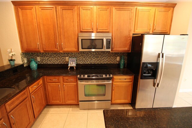 kitchen featuring backsplash, ceiling fan with notable chandelier, stainless steel appliances, sink, and decorative light fixtures