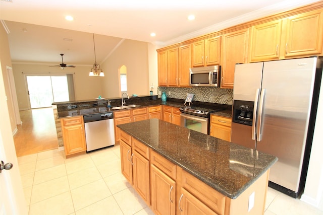 kitchen with stainless steel appliances, vaulted ceiling, ceiling fan, sink, and decorative light fixtures