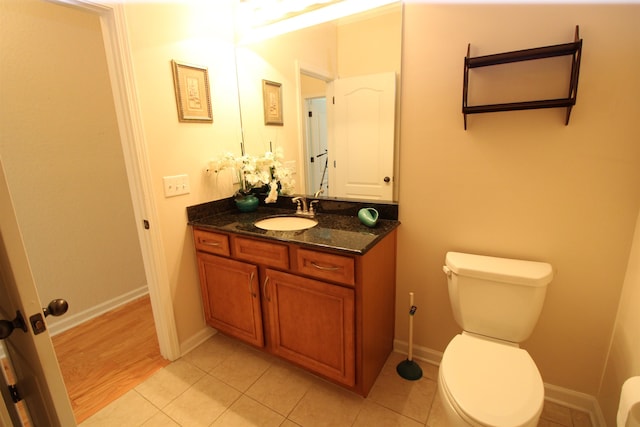 bathroom with toilet, vanity, and hardwood / wood-style flooring