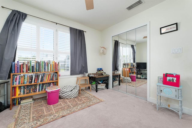 living area featuring carpet and ceiling fan