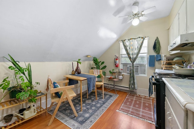 office space with baseboard heating, ceiling fan, hardwood / wood-style floors, and lofted ceiling