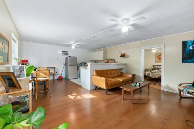 living room featuring a wall unit AC and wood-type flooring