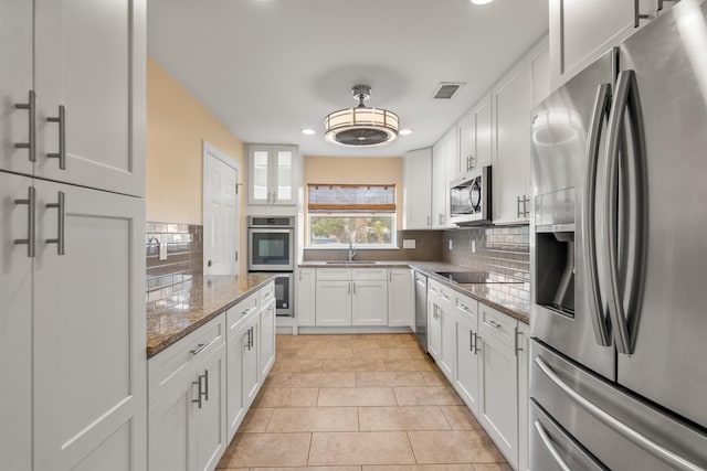 146 Menendez Rd, Saint Augustine, FL 32080 - kitchen featuring white cabinetry, decorative backsplash, and appliances with stainless steel finishes