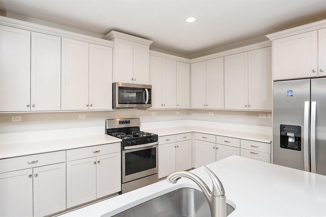 kitchen featuring appliances with stainless steel finishes, sink, and white cabinets