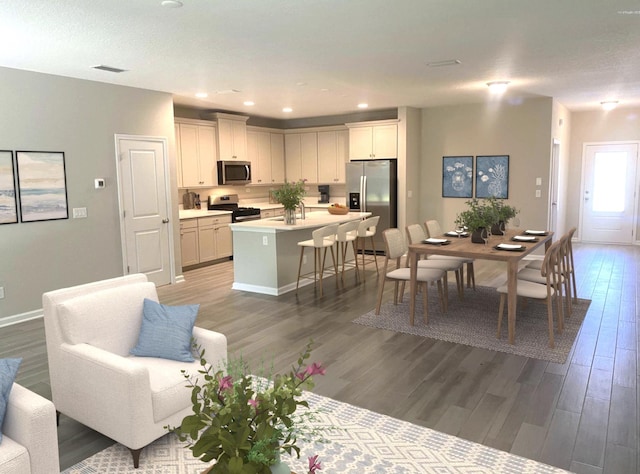 kitchen with stainless steel appliances, a breakfast bar area, wood-type flooring, and a kitchen island