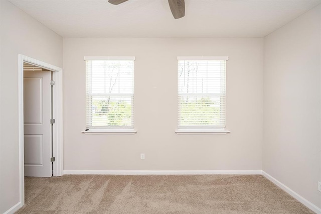 carpeted empty room with ceiling fan and a healthy amount of sunlight