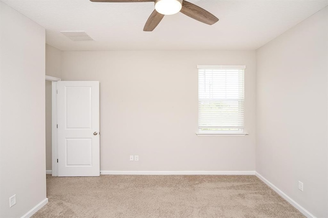 spare room with light colored carpet and ceiling fan