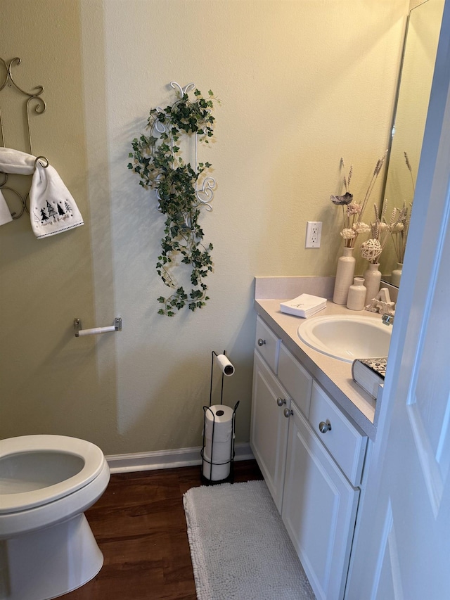 bathroom with toilet, wood-type flooring, and vanity