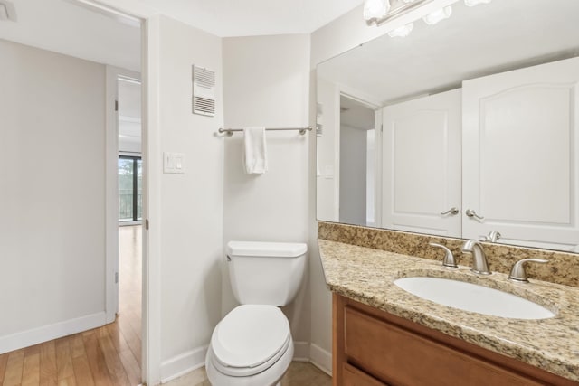 bathroom featuring vanity, hardwood / wood-style floors, and toilet