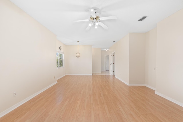 empty room with ceiling fan and light hardwood / wood-style flooring