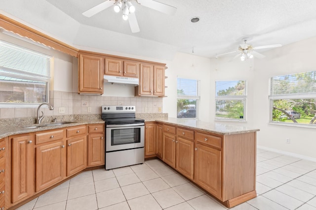 kitchen featuring sink, electric range, light tile patterned floors, and kitchen peninsula