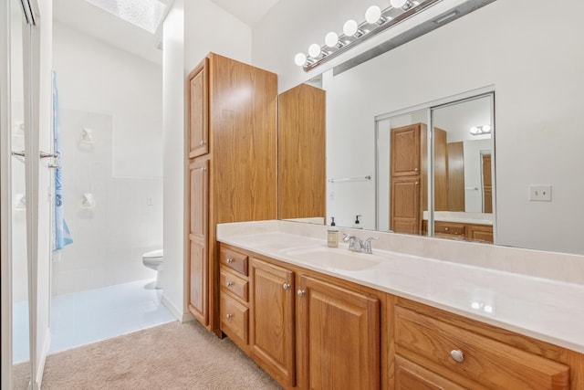 bathroom featuring toilet, walk in shower, and vanity