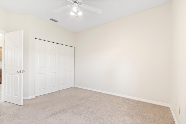 unfurnished bedroom with light carpet, ceiling fan, and a closet