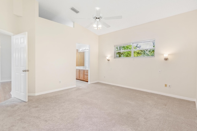 empty room featuring light carpet, ceiling fan, and high vaulted ceiling