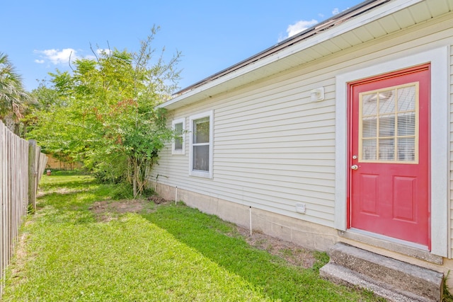 view of exterior entry with a yard