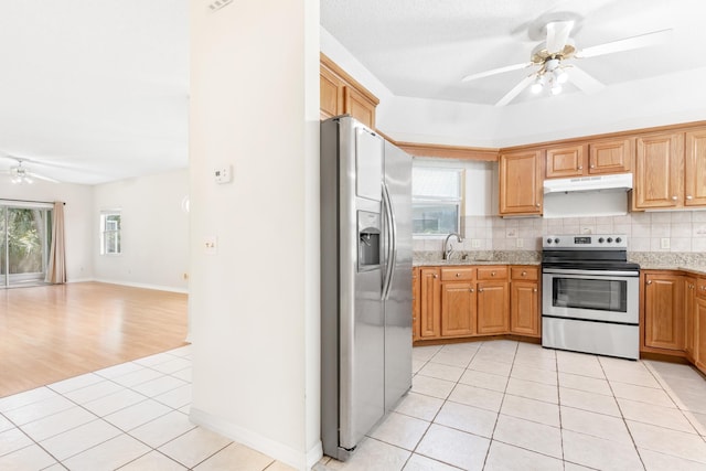 kitchen featuring light tile patterned floors, appliances with stainless steel finishes, tasteful backsplash, and sink