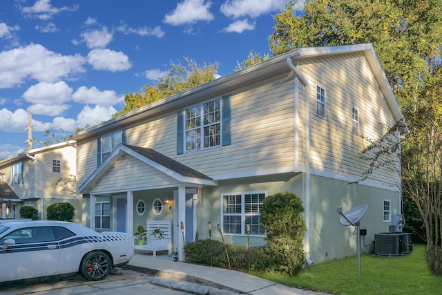 view of front of house with a front yard and central air condition unit