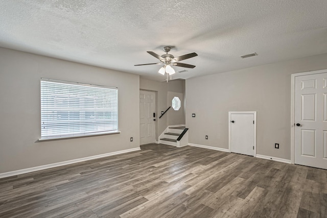 spare room with dark wood-type flooring, ceiling fan, and a textured ceiling