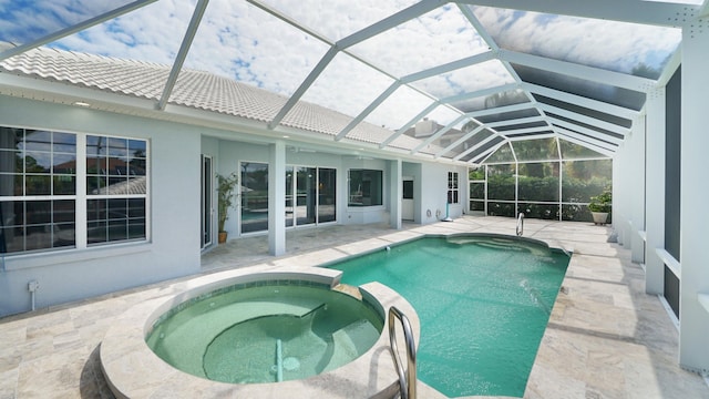 view of swimming pool with an in ground hot tub, glass enclosure, and a patio area