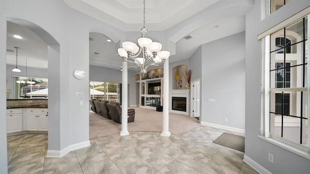 unfurnished dining area featuring a tray ceiling, light colored carpet, and an inviting chandelier