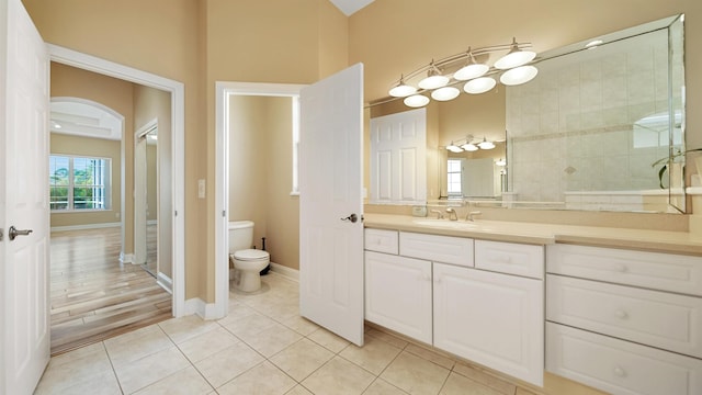 bathroom with tile patterned floors, vanity, toilet, and a shower with shower door