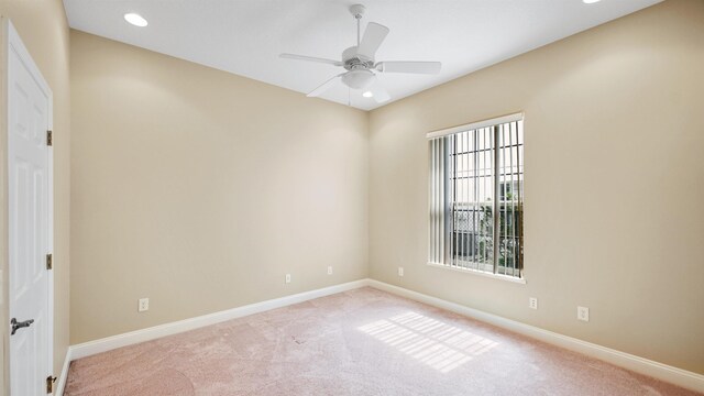 spare room with ceiling fan and light carpet